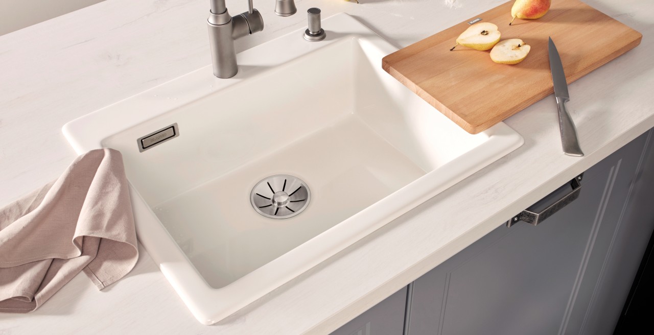 A white sink with cutting board