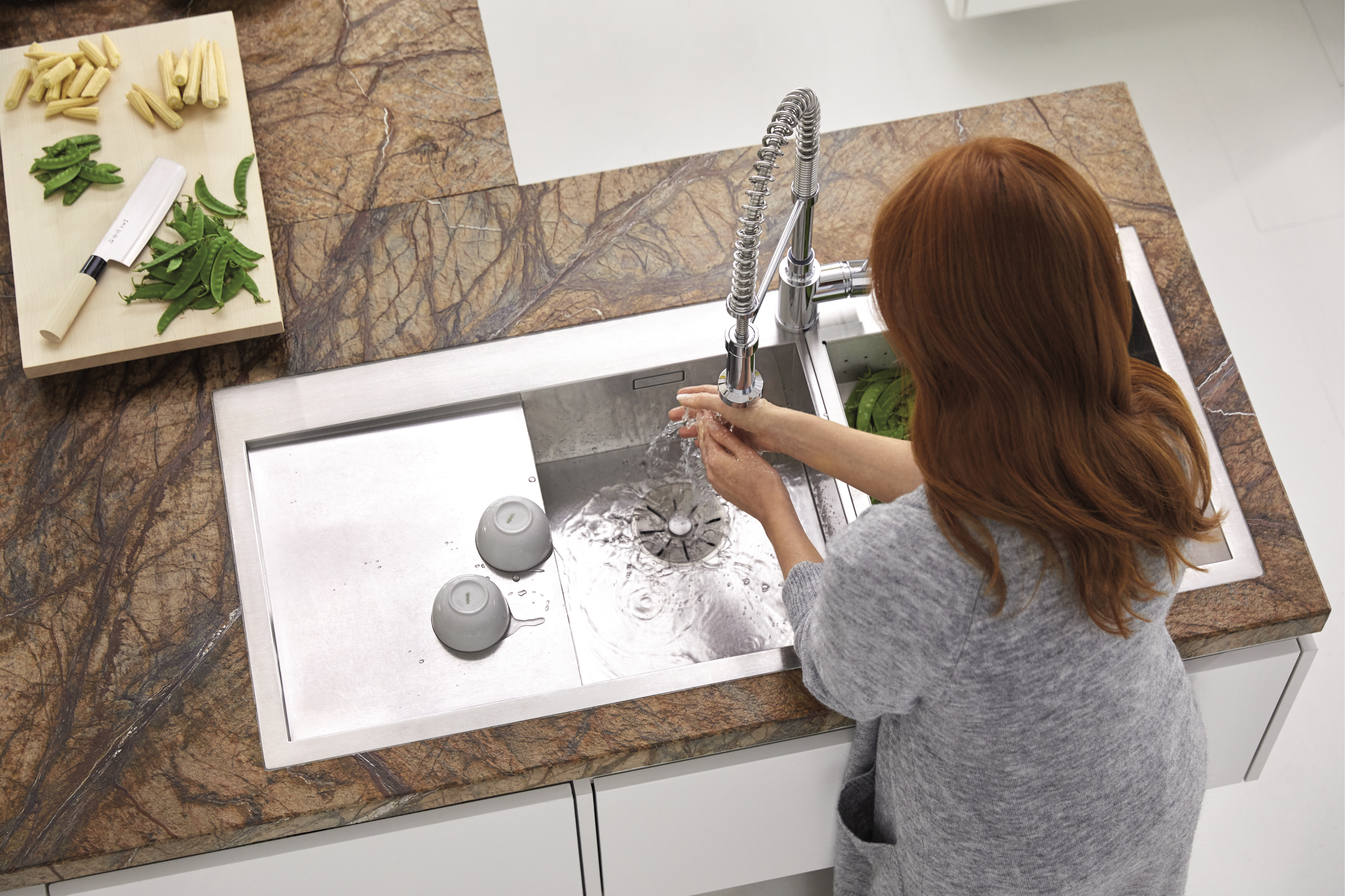 A woman washing her hands in a BLANCO ZEROX sink